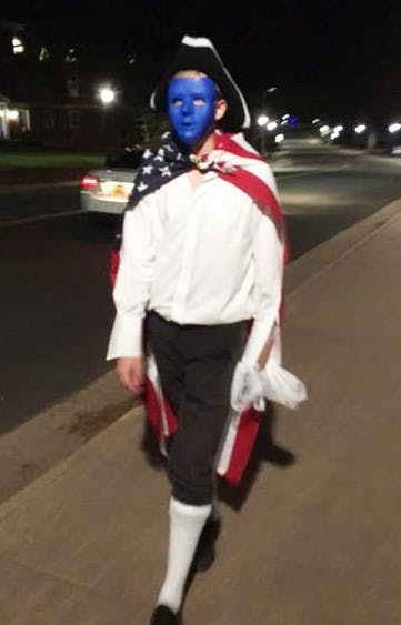 A member of the secret society &mdash; dressed in colonial garb &mdash; helps to distribute the list of rebels and tyrants around Grounds.