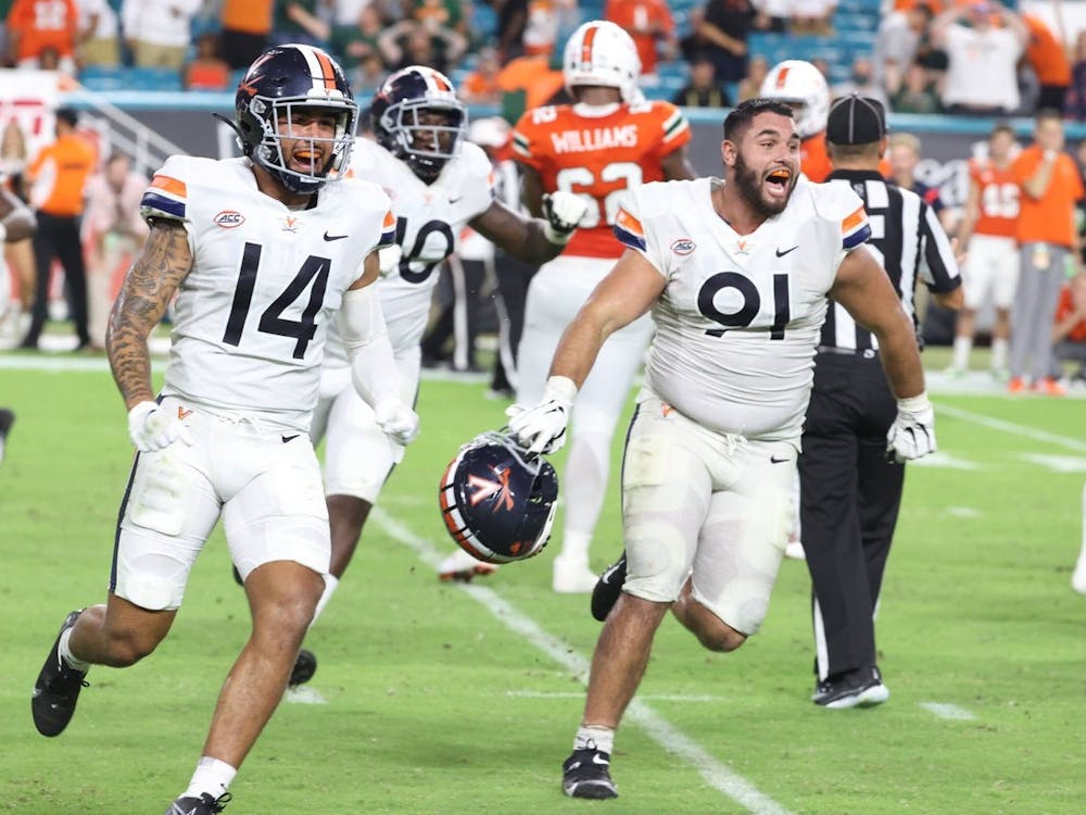 Virginia junior defensive back Antonio Clary and senior defensive end Mandy Alonso celebrate after beating Miami Thursday night.