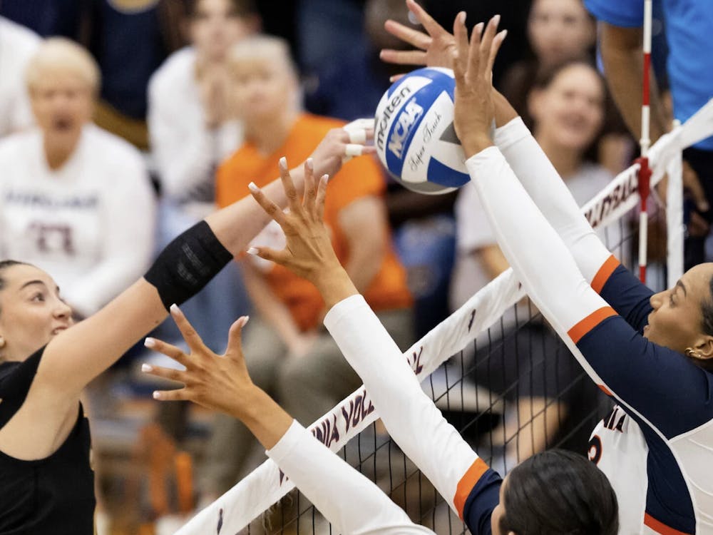 Two Virginia blockers rise up during a match over the weekend against Appalachian State.