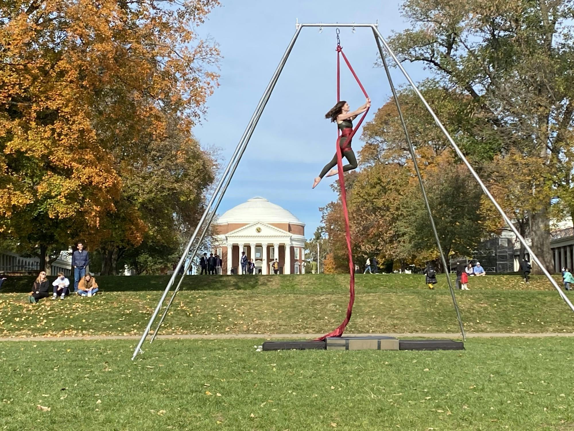 Performers danced using long red and pink pieces of silk fabric hanging from a four-legged metal rig.