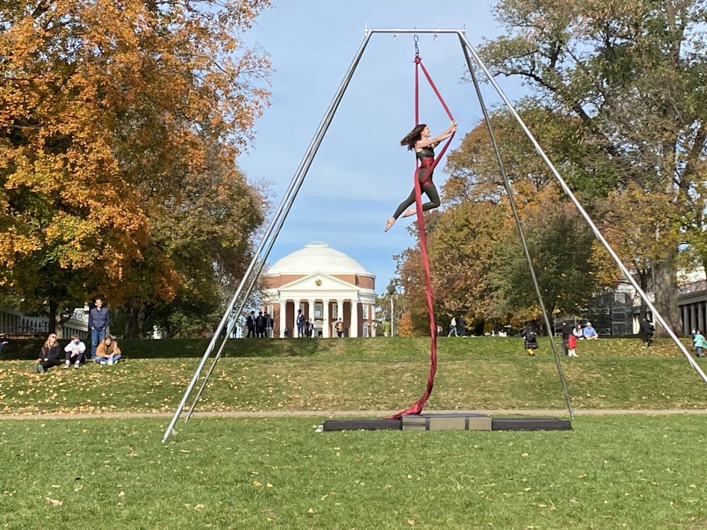 Performers danced using long red and pink pieces of silk fabric hanging from a four-legged metal rig.