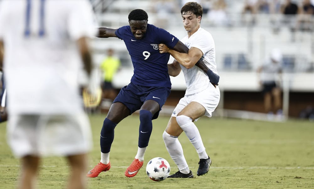 <p>Virginia's AJ Smith holds off a UCLA defender.</p>