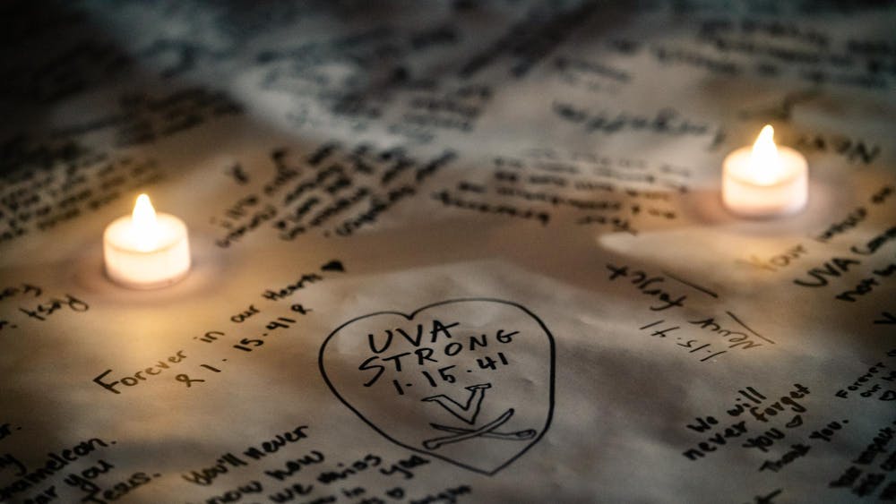 A banner memorializing Lavel Davis Jr., D'Sean Perry and Devin Chandler — the victims of the Nov. 13, 2022 shooting — illuminated in candlelight Nov. 13, 2024.