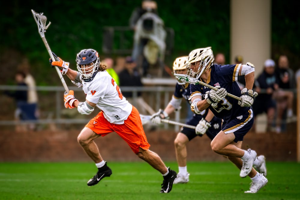 <p>Graduate midfielder Chase Yager is pursued by two Notre Dame players during Saturday's game.</p>