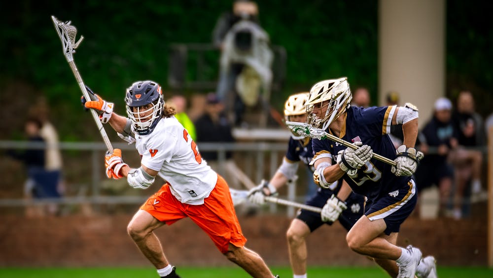 Graduate midfielder Chase Yager is pursued by two Notre Dame players during Saturday's game.