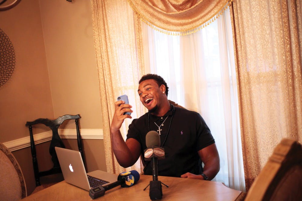 Oscar Smith High School defensive tackle Andrew Brown of Chesapeake, Va. makes an Instagram before announcing on Saturday, June 29, 2013 in his home that he will be playing football at the University of Virginia. (Dorothy Edwards | The Virginian-Pilot)