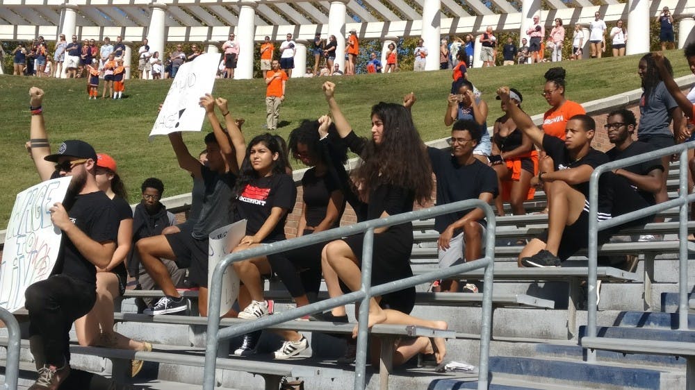 <p>Students marched down McCormick Road to Scott Stadium clad in black and carrying signs protesting institutional racism and the rescinding of DACA.</p>