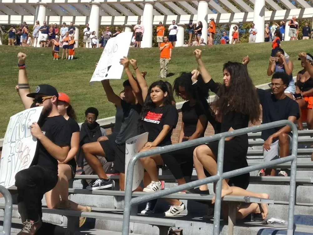 Students marched down McCormick Road to Scott Stadium clad in black and carrying signs protesting institutional racism and the rescinding of DACA.