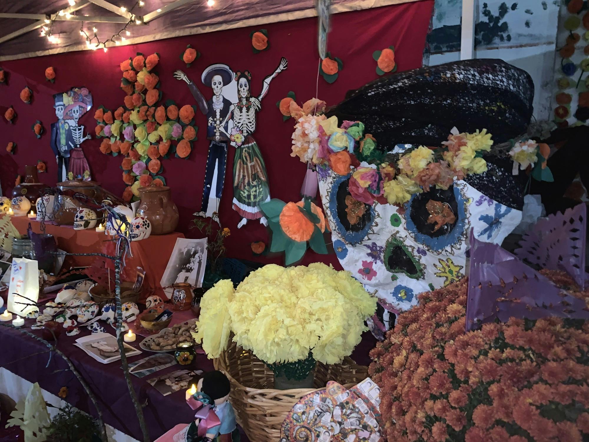 One of the multiple altars at the festival, adorned with flowers and paper marigolds. The vibrant colors of the skulls represent those who have passed.