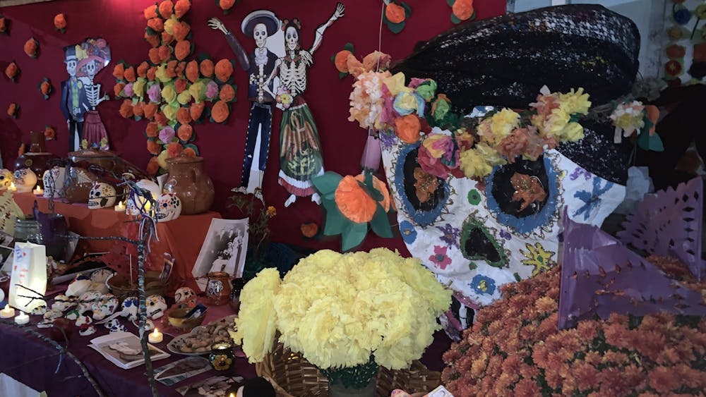 One of the multiple altars at the festival, adorned with flowers and paper marigolds. The vibrant colors of the skulls represent those who have passed.