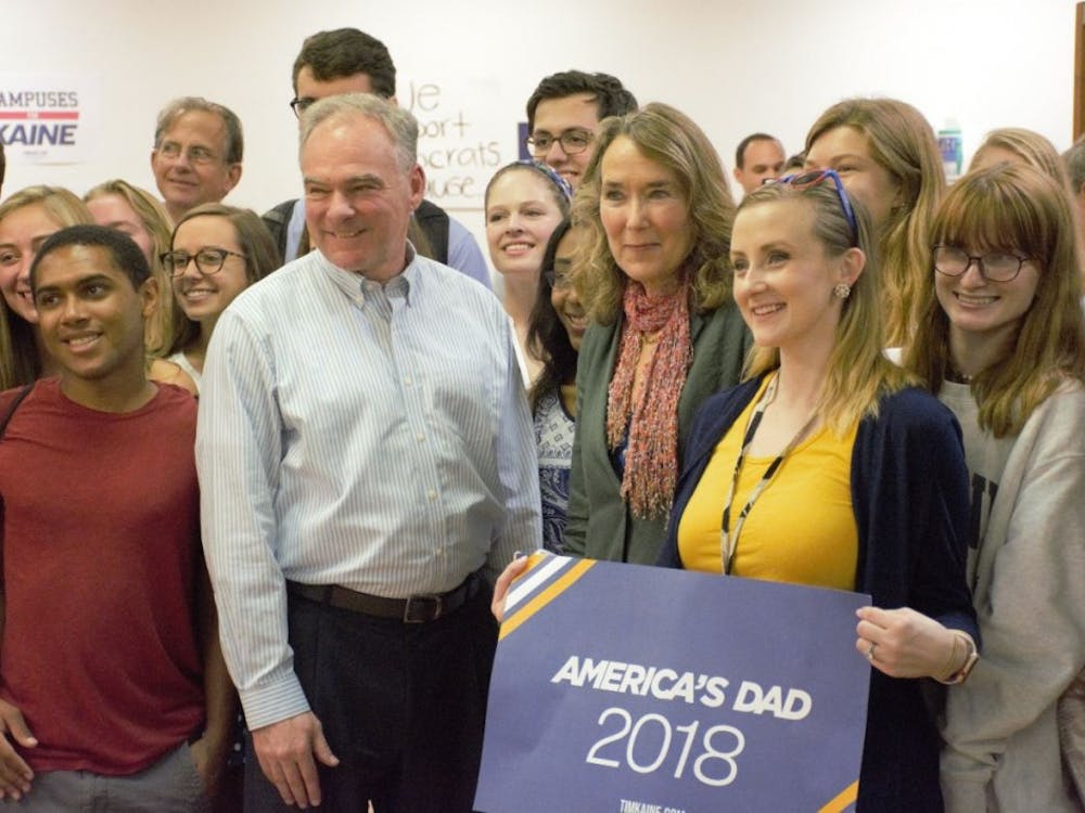 Sen. Tim Kaine and Leslie Cockburn pose for a picture with members of the University Democrats.&nbsp;