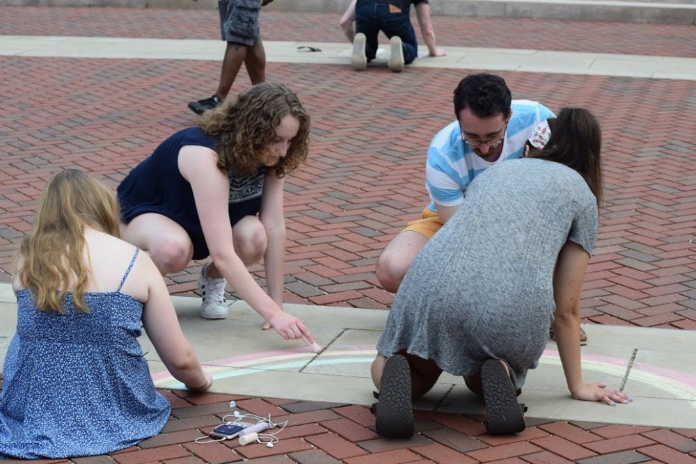 <p>The event started with attendees chalking the sidewalk with messages of support for the victims of the shooting.</p>