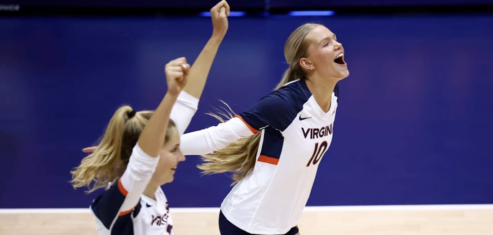 <p>Freshman striker Zoey Dood and senior middle blocker Abby Tadder celebrate after scoring another Virginia point.</p>