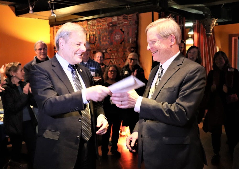Local criminal defense attorney Lloyd Snook (right) receives a check from Del. David Toscano (D-Charlottesville) during Snook's City Council campaign launch at Bashir's Taverna Tuesday.&nbsp;