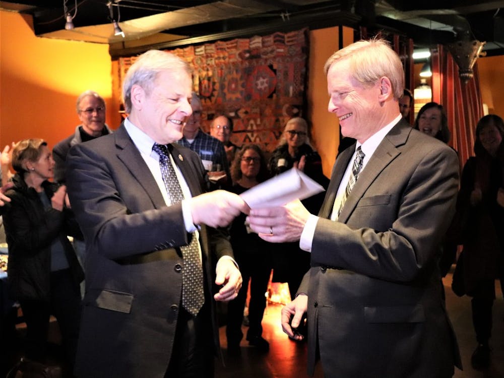 Local criminal defense attorney Lloyd Snook (right) receives a check from Del. David Toscano (D-Charlottesville) during Snook's City Council campaign launch at Bashir's Taverna Tuesday.&nbsp;