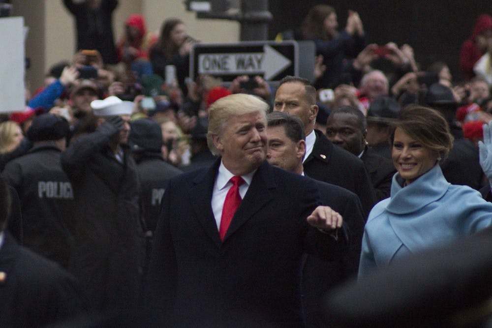 President Donald Trump and first lady Melania Trump smile at the crowd on Inauguration Day.