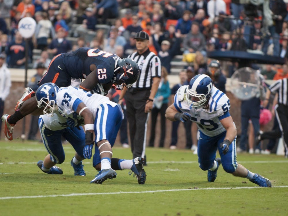 	Kevin parks leaps over Duke defenders to score a touchdown for Virginia in a 35-22 loss.