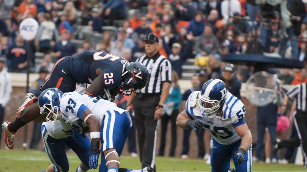 	Kevin parks leaps over Duke defenders to score a touchdown for Virginia in a 35-22 loss.