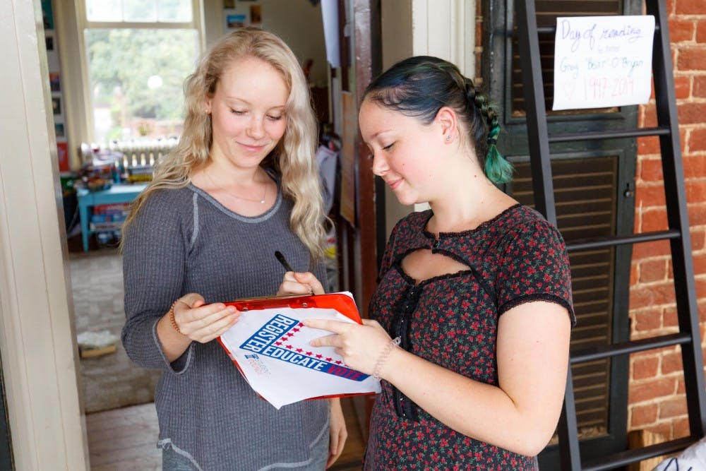A student registers to vote outside a Lawn room.
