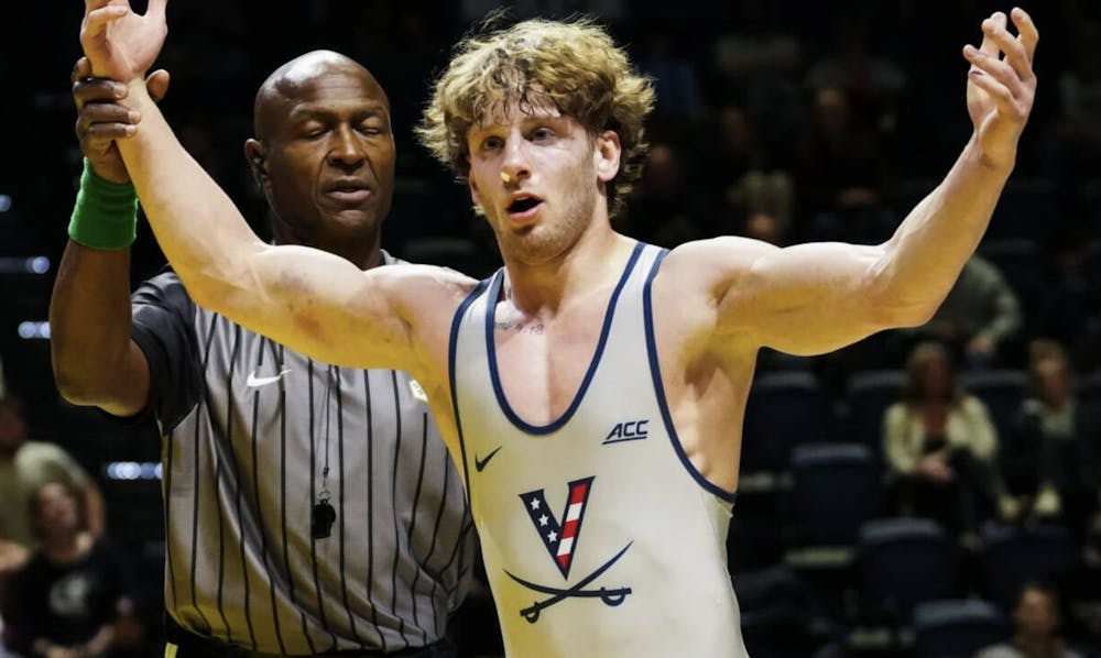 <p>Dylan Cedeno rises off the mat, arms raised, after one of his many wins.</p>