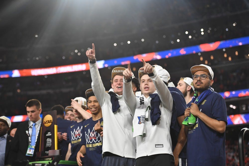 <p>Senior student managers Grant Kersey, Justin Maxey and Faris Wasim celebrate Virginia's first National Championship in program history in Minneapolis.</p>