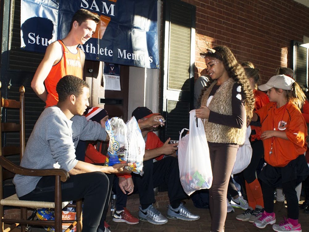 Volunteers on the Lawn pass out candy to trick-or-treaters.