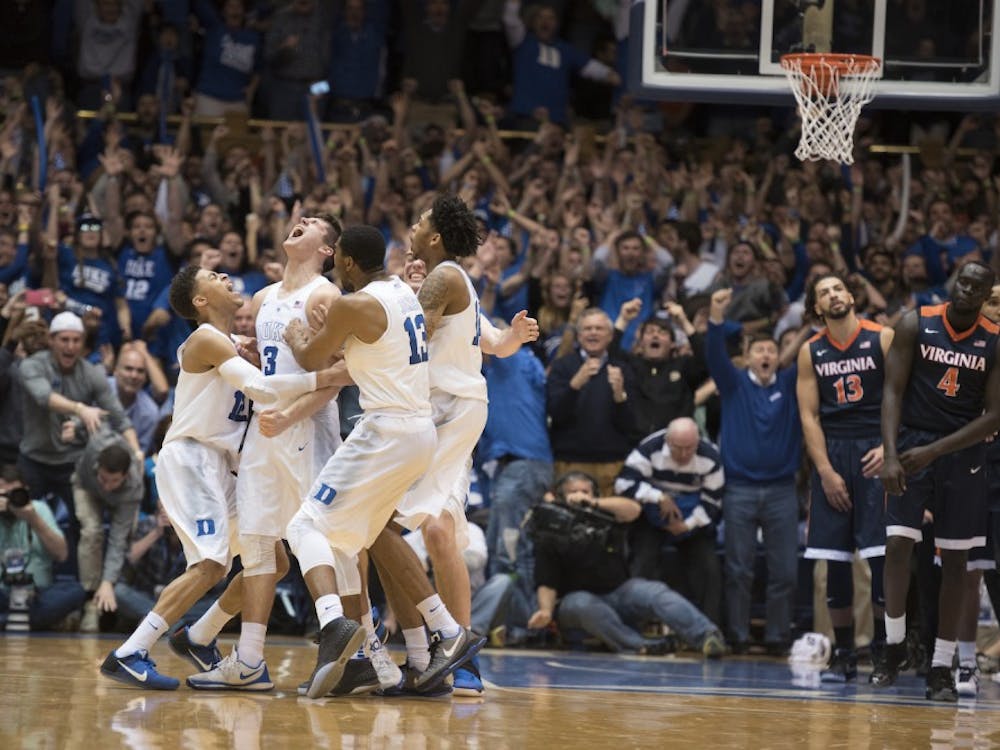 Virginia players look on as Duke celebrates a buzzer-beater by Grayson Allen, which handed the Blue Devils a 63-62 win against the Cavaliers.