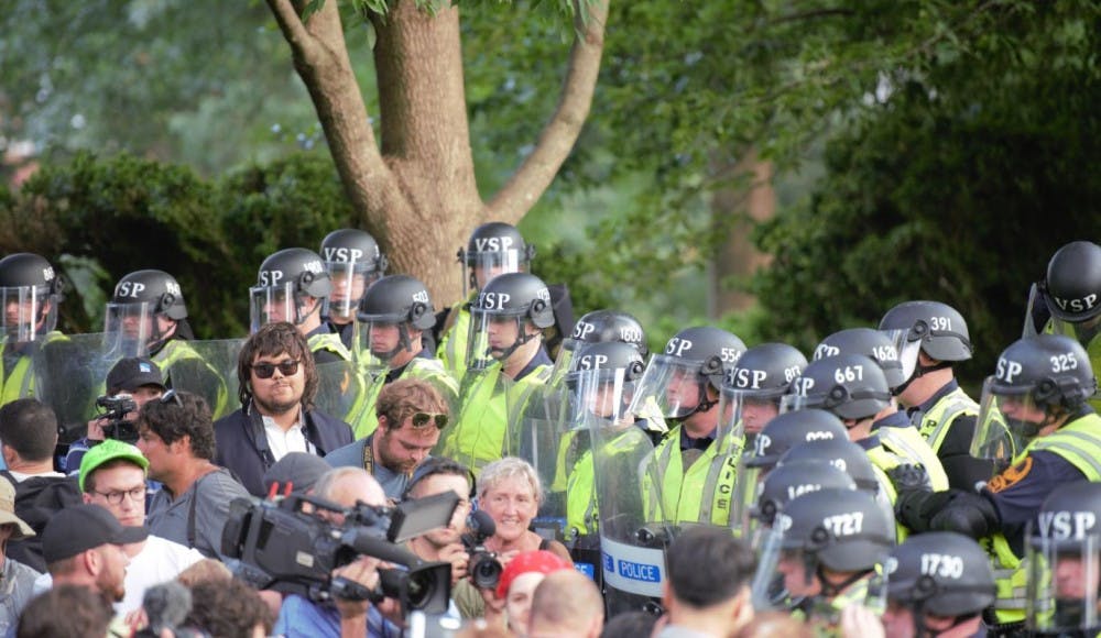 Virginia State Police officers form a line between demonstrators and the adjacent Academical Village during a rally organized by U.Va. Students United near Brooks Hall Saturday Aug. 11, 2018.&nbsp;
