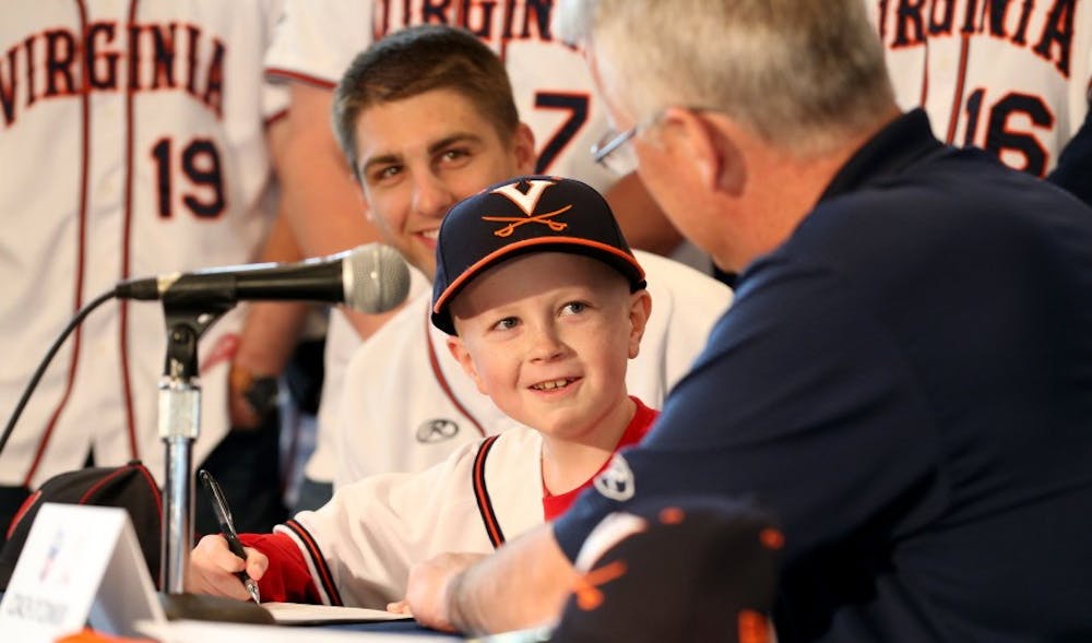 <p>John "Parker" Staples &nbsp;signed a draft day letter during a press conference while surrounded by the entire Virginia baseball squad April 16.</p>
