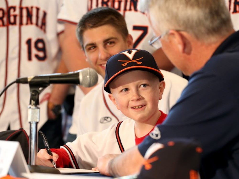 John "Parker" Staples signed a draft day letter during a press conference while surrounded by the entire Virginia baseball squad April 16.