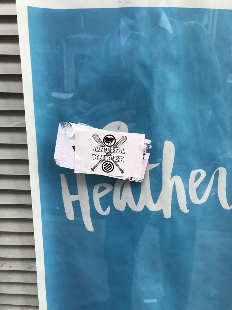 As of Monday evening, the flyers around Heather Heyer Way had been destroyed and replaced with anti-fascist stickers.