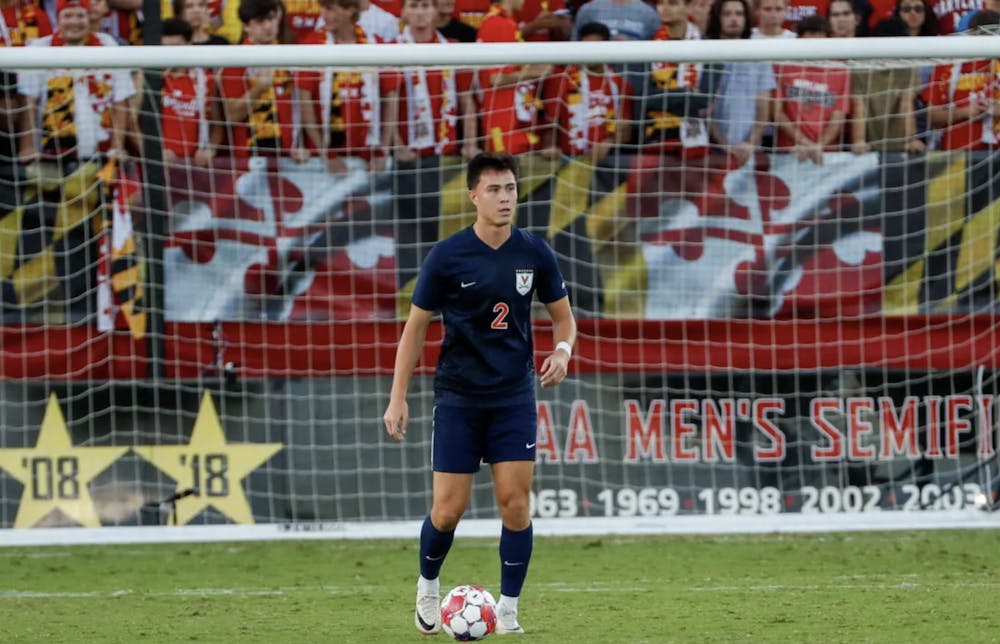 <p>Nick Dang, with a wall of home supporters rising behind him, looks to pass.</p>