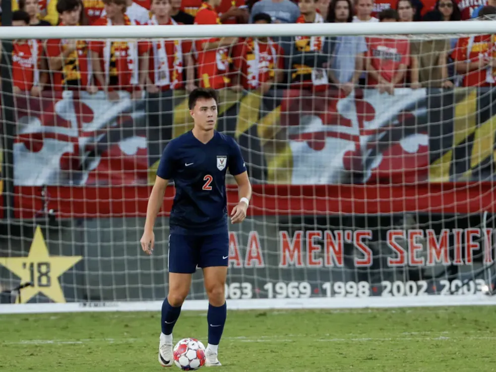 Nick Dang, with a wall of home supporters rising behind him, looks to pass.
