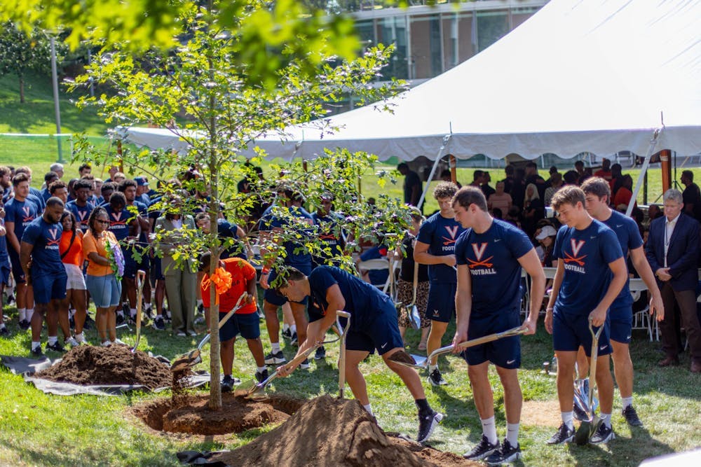 以弗吉尼亚大学校长Jim Ryan、体育部主任Carla Williams和校董会长Robert Hardie打头，每一位到场者都被邀请在树前添上一捧土。