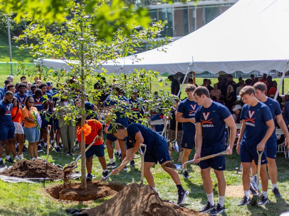 以弗吉尼亚大学校长Jim Ryan、体育部主任Carla Williams和校董会长Robert Hardie打头，每一位到场者都被邀请在树前添上一捧土。