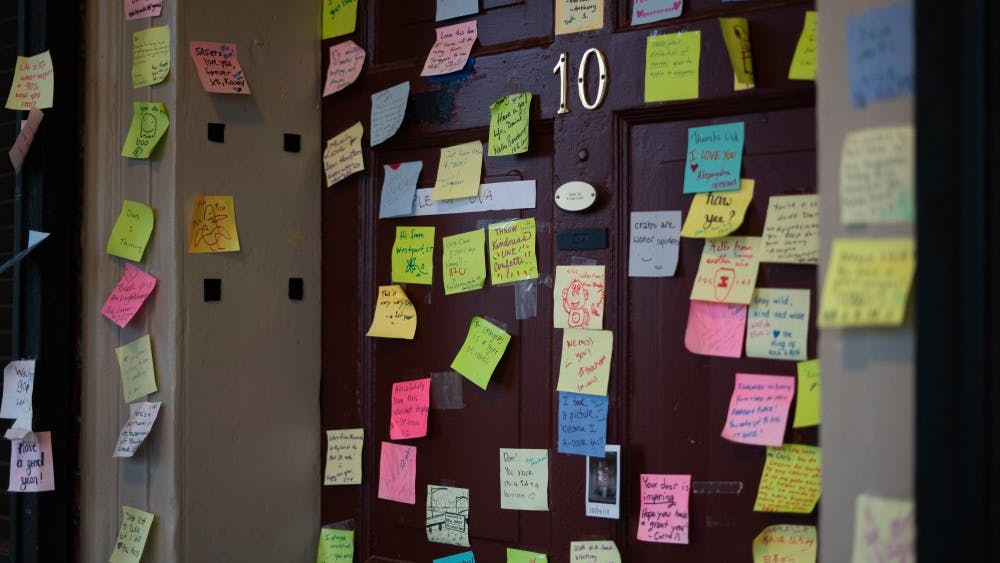 Fourth-year Global Healthy Policy student Dan Xia's Lawn room door is decorated with sticky notes ranging from positive messages to light-hearted doodles. 