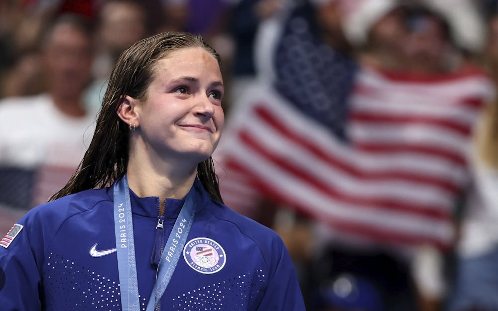 Grimes smiles on the podium, having won a silver medal for the United States.