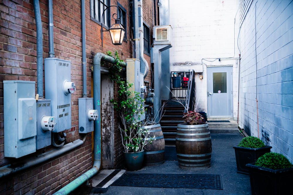 <p>The restaurant itself hides behind a wooden barn door, and the only signage is a large, glowing lantern hanging above it, illuminating the otherwise onyx street.</p>