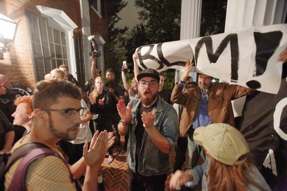 <p>The group of protesters stood outside University President Teresa Sullivan’s residence chanting multiple slogans, including, &nbsp;“Black lives matter,” “Blood on your hands,” “This racist system’s got to go” and “No justice, no peace, f—k the police.” &nbsp;</p>