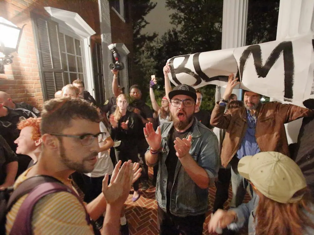 The group of protesters stood outside University President Teresa Sullivan’s residence chanting multiple slogans, including, “Black lives matter,” “Blood on your hands,” “This racist system’s got to go” and “No justice, no peace, f—k the police.” 