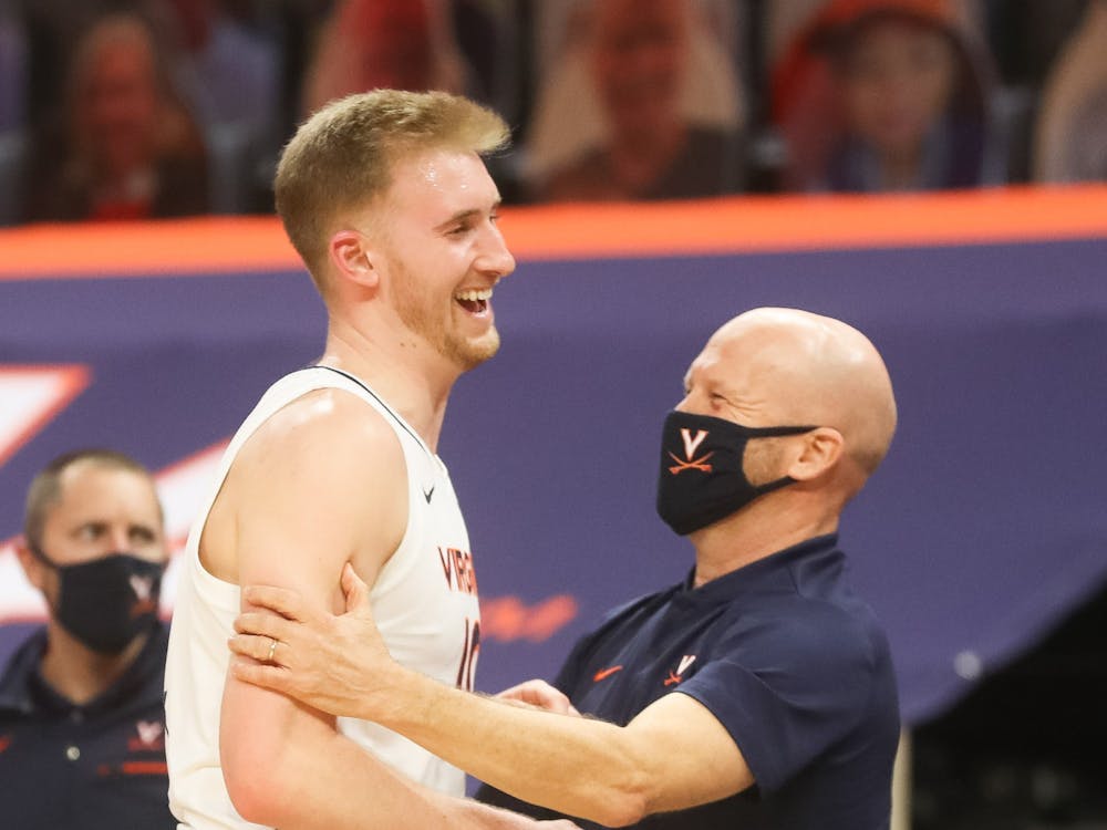 Virginia senior forward Sam Hauser celebrates with assistant coach Brad Soderberg after coming off the court late in the game.