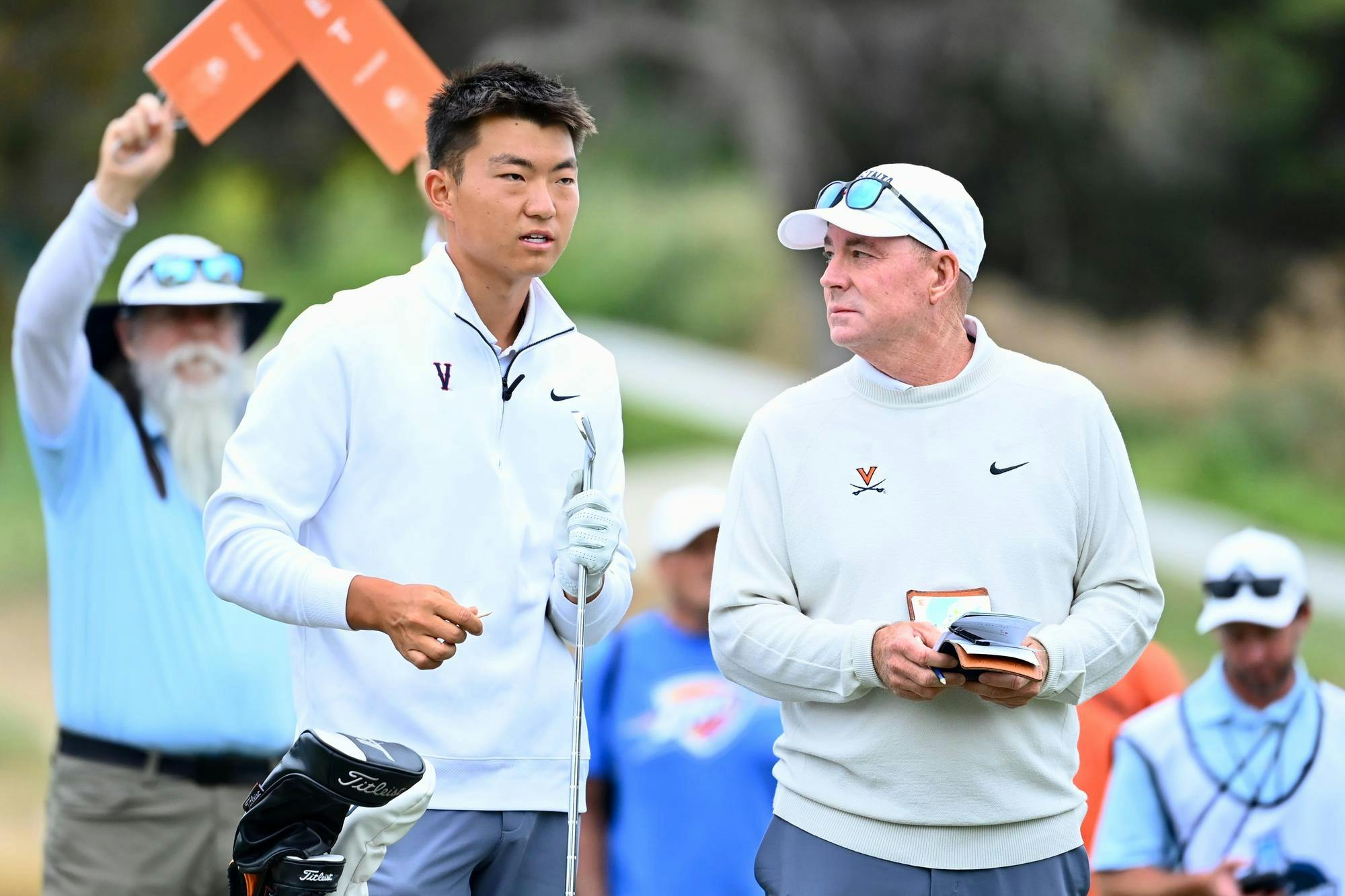 Coach Bowen Sargent and Bryan Lee confer on the tee during the final.
