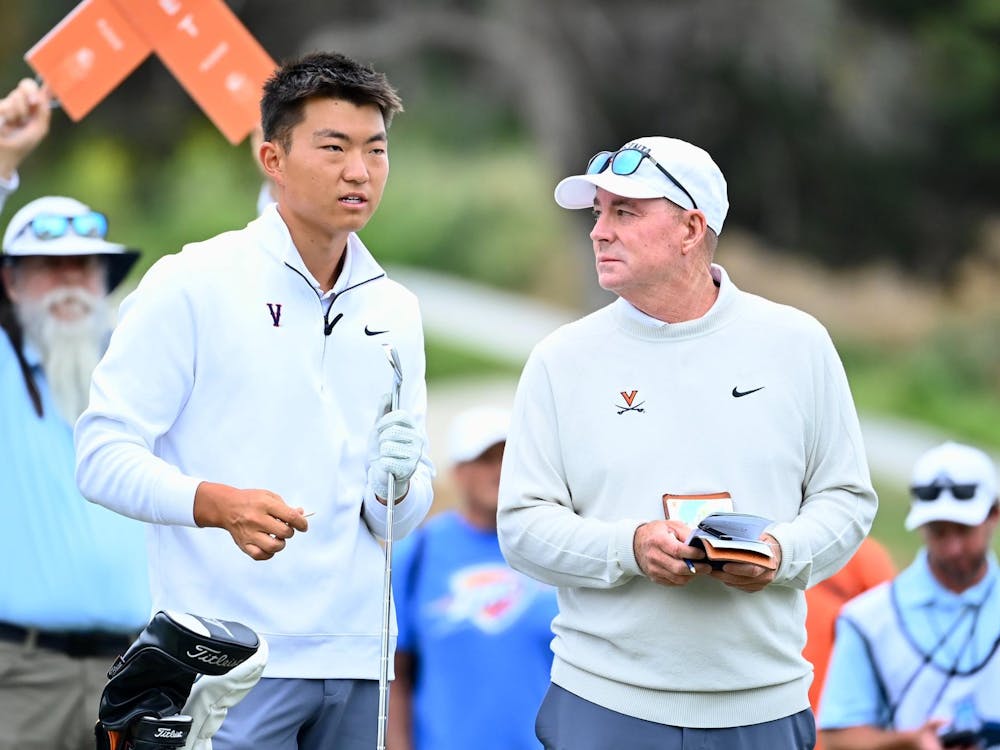 Coach Bowen Sargent and Bryan Lee confer on the tee during the final.