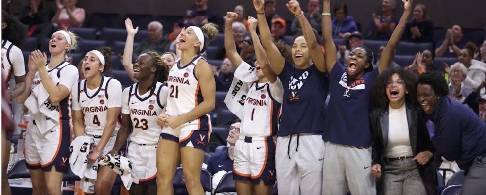 <p>The Cavalier bench celebrates a crucial three point shot.</p>