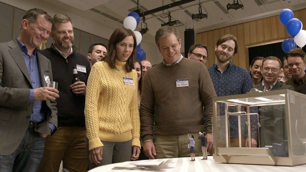Kristen Wiig (left) and Matt Damon (right) star in the movie "Downsizing," which focuses on a process that shrinks one's body and cost of living.