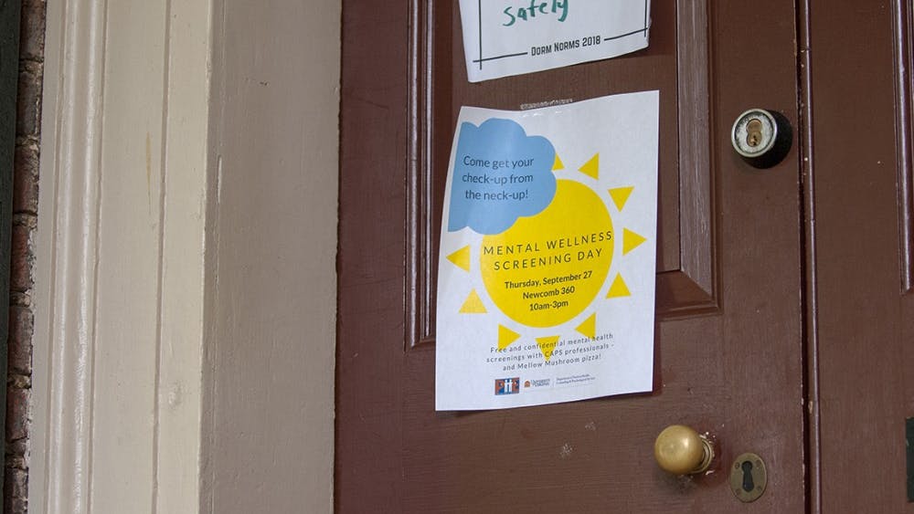 A poster for Mental Wellness Screening Day taped to a Lawn room door