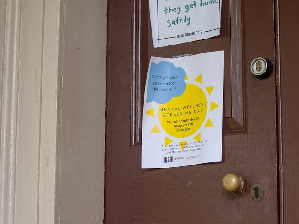 A poster for Mental Wellness Screening Day taped to a Lawn room door