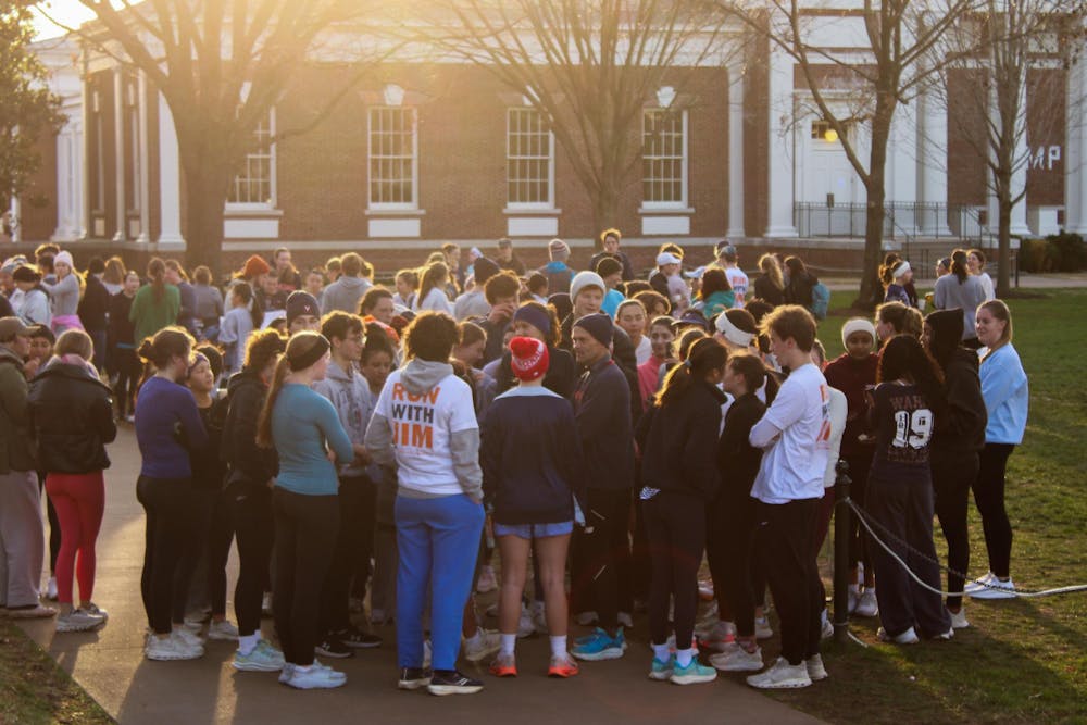 <p>Students gather around former President Jim Ryan at South Lawn, after the "Run with Jim," photographed Dec. 4.</p>