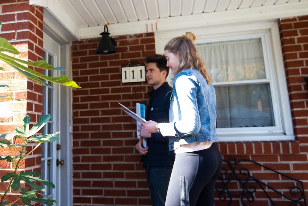 Jackson Samples, University Democrats campaign chair and a third-year College student, and Mary Alice Kukoski, University Democrats President and a third-year College student, knock doors near Buford Middle School Saturday.&nbsp;