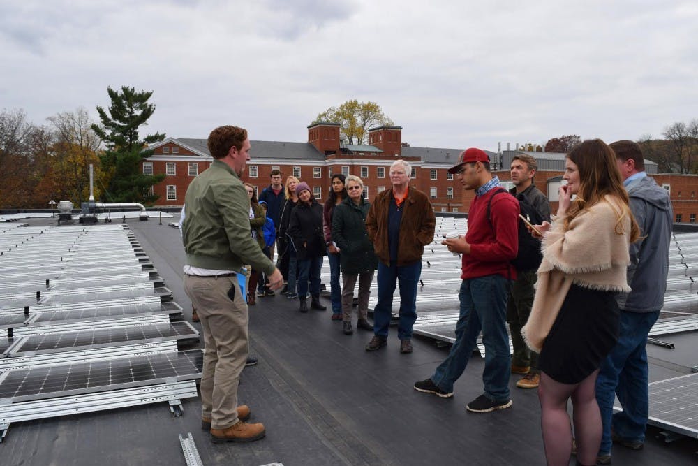 A tour looks at solar panels installed on the roof of Ruffner Hall.&nbsp;